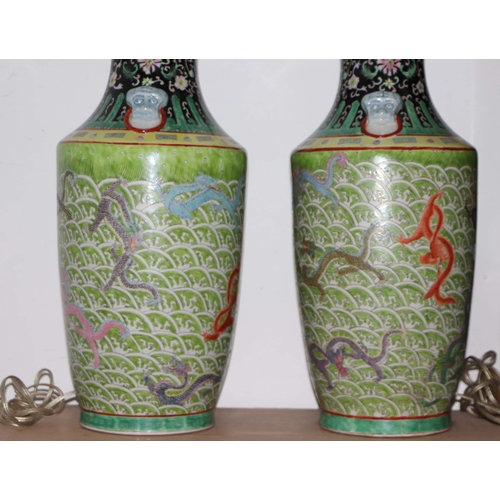 898 - A pair of Chinese famille vert vase table lamps decorated with dragons amongst waves; six character ... 