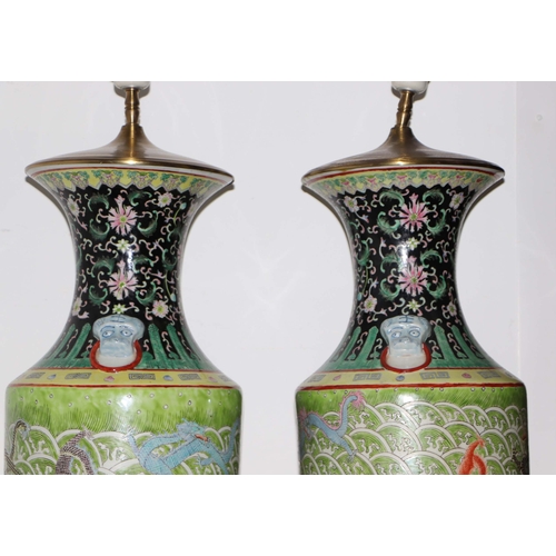 898 - A pair of Chinese famille vert vase table lamps decorated with dragons amongst waves; six character ... 