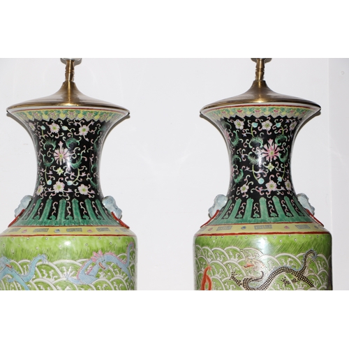 898 - A pair of Chinese famille vert vase table lamps decorated with dragons amongst waves; six character ... 