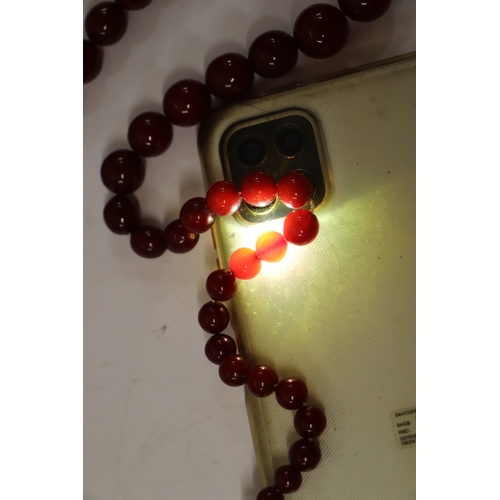 713 - A graduated cherry amber bead necklace, 48g, approx 72cm long.