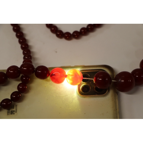 713 - A graduated cherry amber bead necklace, 48g, approx 72cm long.