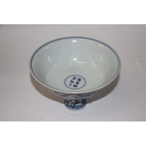 807 - A Chinese blue and white stem cup decorated with figures within a garden scene, 17cm diameter