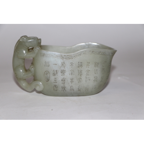 868 - A late Chinese Republic jade vessel decorated with calligraphy and having a carved dragon handle, 13... 