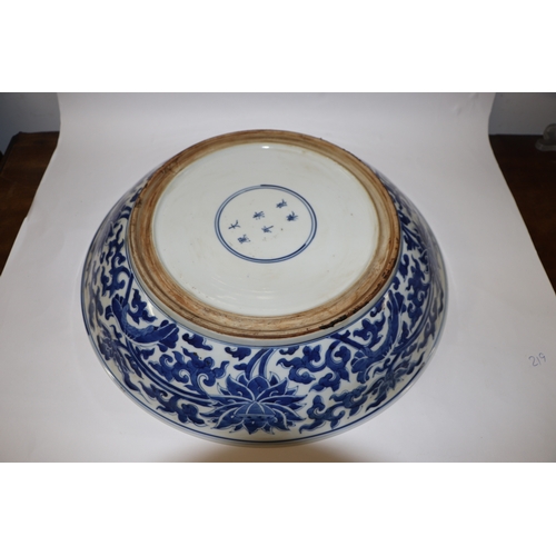 881 - A large Chinese blue and white shallow bowl decorated with flowering foliage, six character mark to ... 