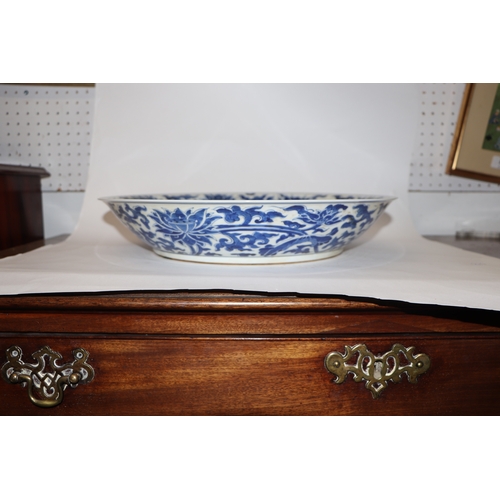 881 - A large Chinese blue and white shallow bowl decorated with flowering foliage, six character mark to ... 