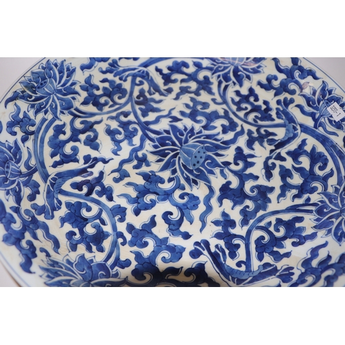 881 - A large Chinese blue and white shallow bowl decorated with flowering foliage, six character mark to ... 