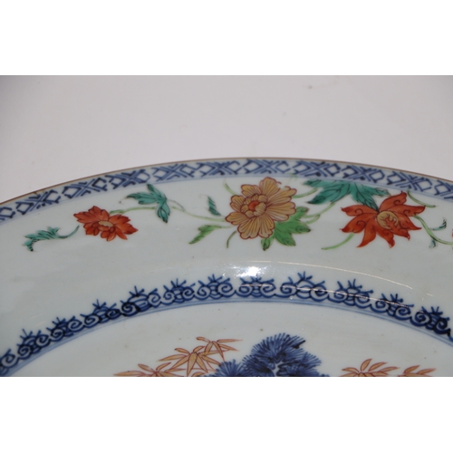 882 - A Chinese famille rose charger decorated with a fir tree and a terrace, 32cm diameter.