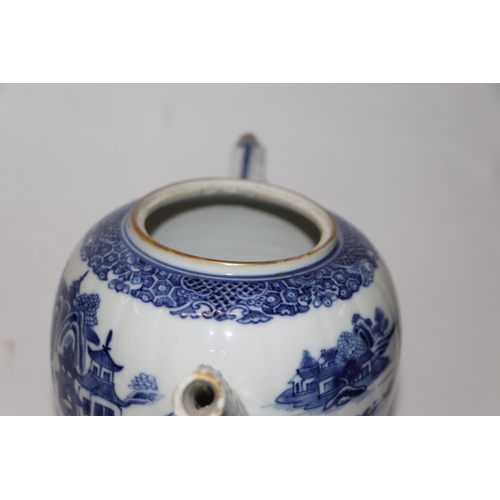 887 - A Chinese blue and white teapot decorated with a river landscape scene, 15cm high.