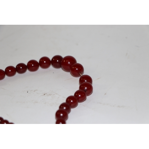 713 - A graduated cherry amber bead necklace, 48g, approx 72cm long.