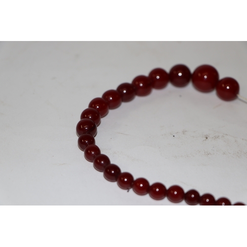 713 - A graduated cherry amber bead necklace, 48g, approx 72cm long.