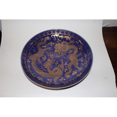 786 - A Chinese gilt decorated blue ground bowl depicting dragons amongst clouds chasing a flaming pearl, ... 