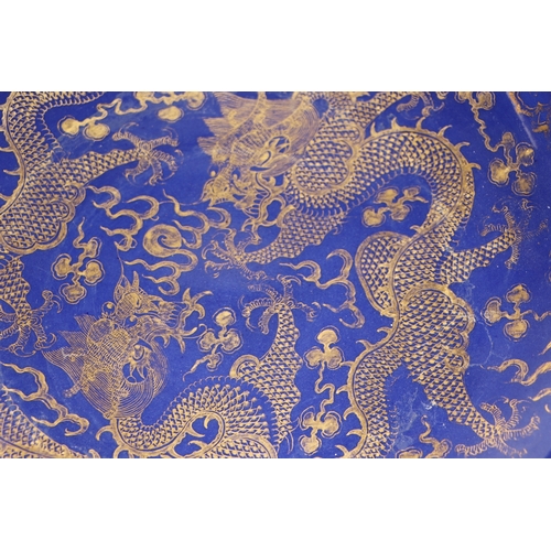 786 - A Chinese gilt decorated blue ground bowl depicting dragons amongst clouds chasing a flaming pearl, ... 