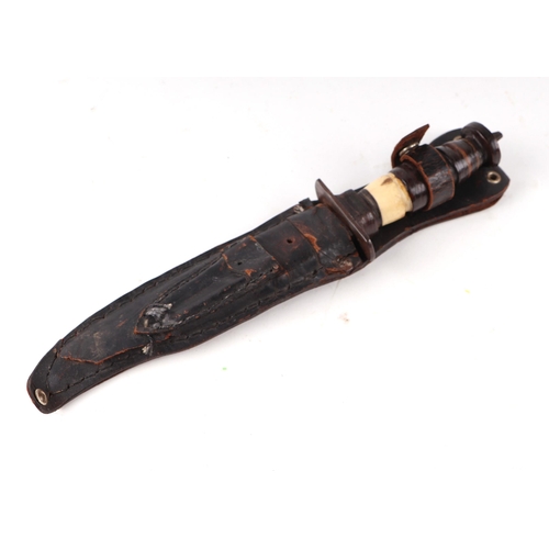 115 - An early 20th century sawback Bowie knife in its leather scabbard. Havinga part bone hilt. Blade len... 