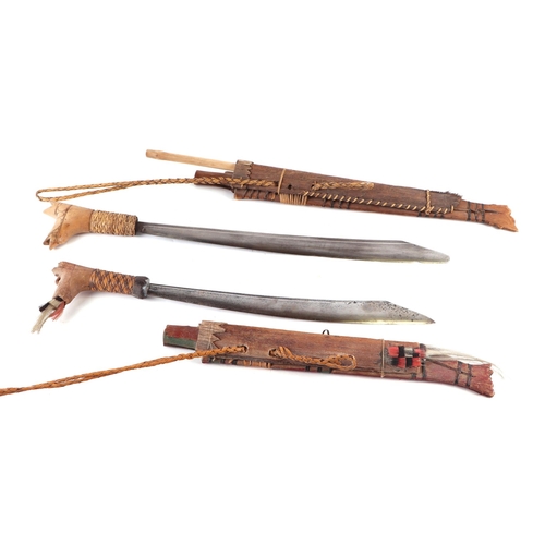 132 - A South American machete with painted wooden scabbard, 55cm long; together with another similar larg... 