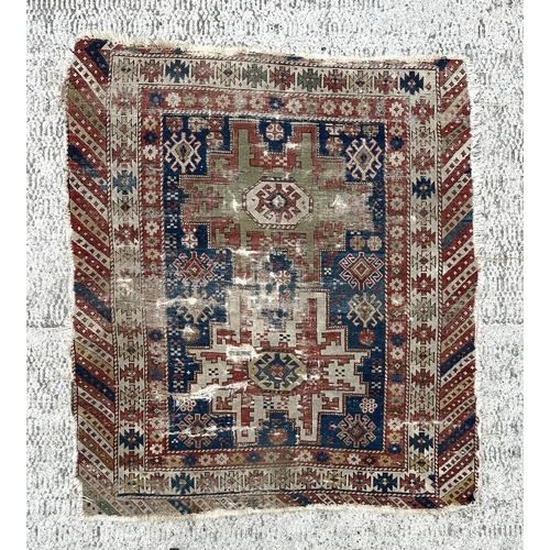 142 - An antique Caucasian rug, 100 by 114cms (wear and damages).