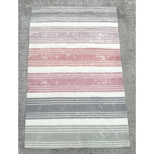 150 - A modern Designer's Guild floor rug with pastel shade stripes, 245 by154cms.