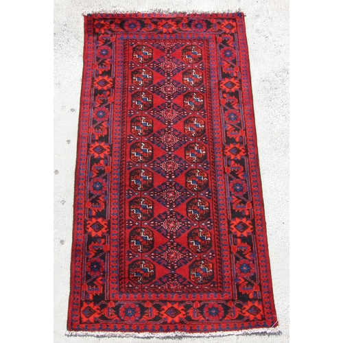 153 - A Persian Turkoman hand knotted runner with repeat geometric design, on a red ground, 230 by 117cms ... 