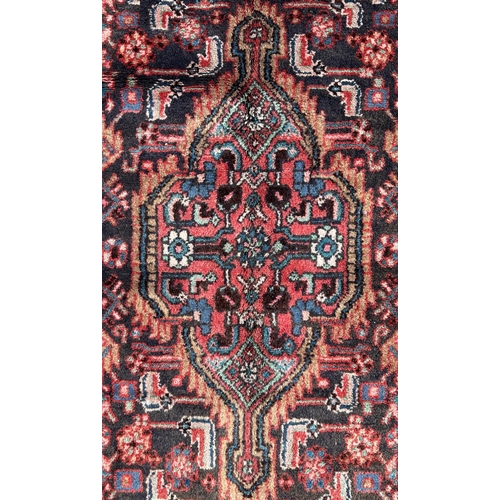 156 - A Persian Hamadan runner on a red ground, 280 by 80cms (333).