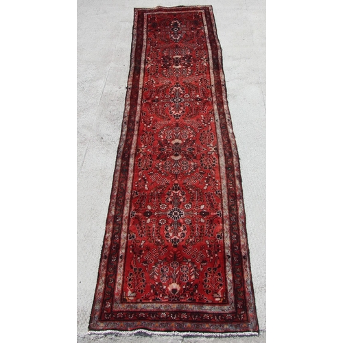 162 - A Persian Tabriz long woollen runner with six central floral medallions, on a red ground, 420 by 100... 