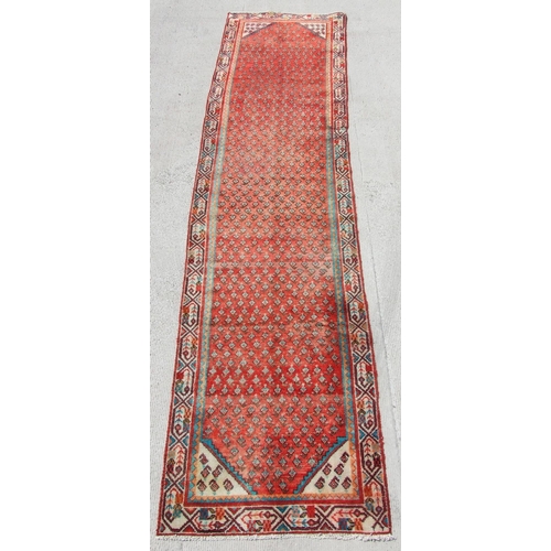 165 - A Persian Saraband runner with all over design within stylised borders, on a red ground, 390 by 90cm... 