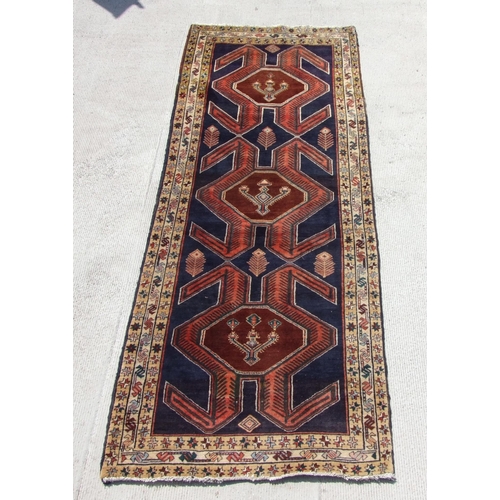 166 - A Persian hand knotted Afshar runner with central stylised design, on a navy ground, 290 by 110cms.