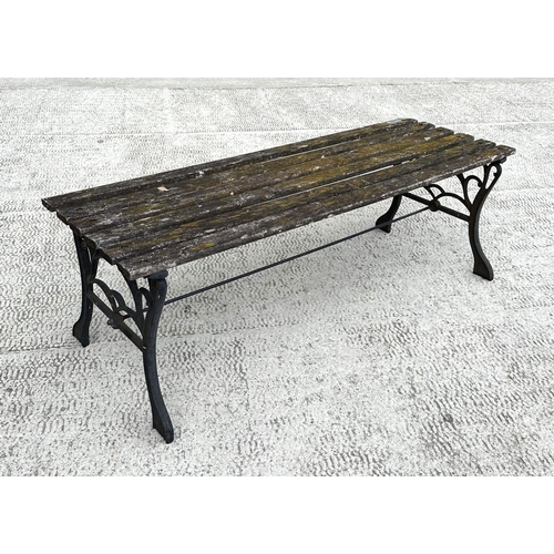 17 - A well weathered slatted wooden garden bench with cast iron supports, 122cm wide.