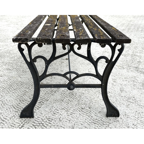 17 - A well weathered slatted wooden garden bench with cast iron supports, 122cm wide.