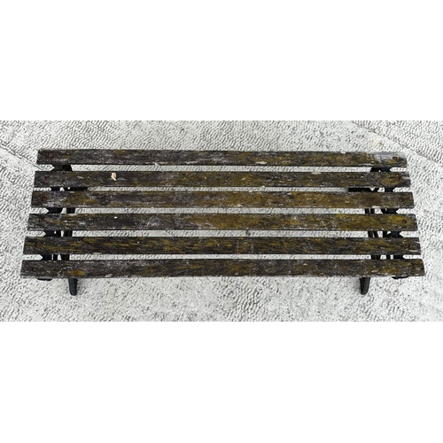 17 - A well weathered slatted wooden garden bench with cast iron supports, 122cm wide.