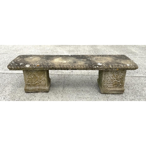 19 - A well weathered reconstituted stone garden bench, having a rectangular top, on square supports, 120... 