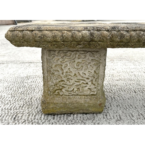 19 - A well weathered reconstituted stone garden bench, having a rectangular top, on square supports, 120... 