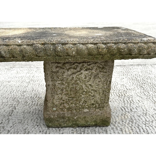 19 - A well weathered reconstituted stone garden bench, having a rectangular top, on square supports, 120... 