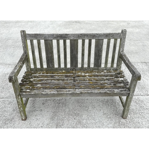 20 - A well weathered teak slatted garden bench, 122cm wide.