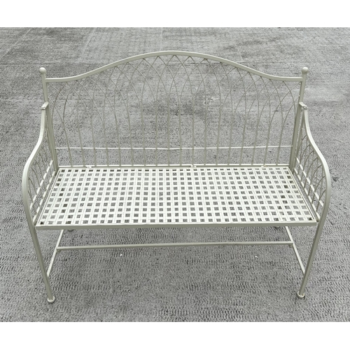 28 - A cream painted metal garden bench with arched back, 115cms wide.