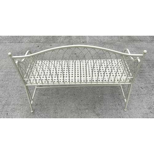 28 - A cream painted metal garden bench with arched back, 115cms wide.