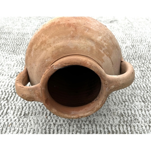 36 - A large terracotta two-handled amphora oil jar, 77cms high.