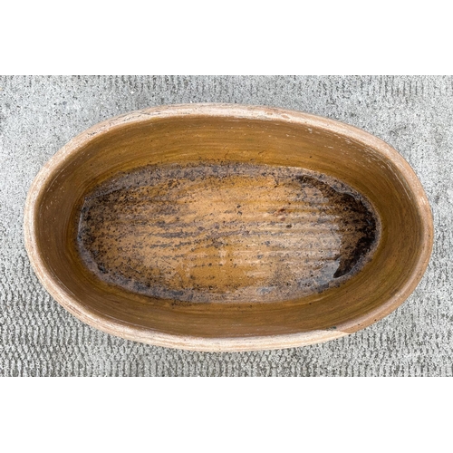 38 - A 19th century part glazed oval two-handled chitterling trough, 62cms wide.