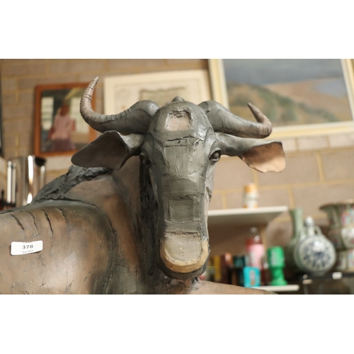 378 - Nichola Theakston MA (modern British) - a ceramic reclining wildebeest sculpture, 75cm wide.