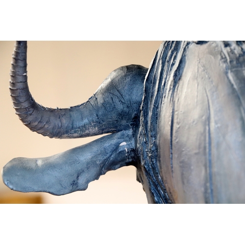 378 - Nichola Theakston MA (modern British) - a ceramic reclining wildebeest sculpture, 75cm wide.