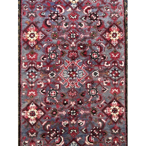 118 - A Persian woollen hand knotted runner with repeat geometric designs within floral borders, on a beig... 