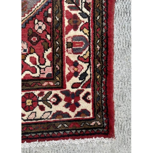 118 - A Persian woollen hand knotted runner with repeat geometric designs within floral borders, on a beig... 