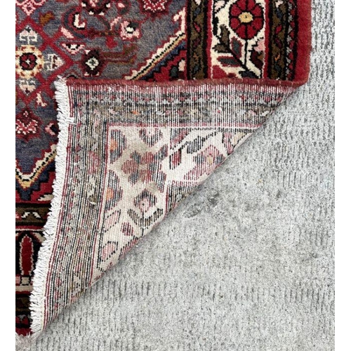 118 - A Persian woollen hand knotted runner with repeat geometric designs within floral borders, on a beig... 