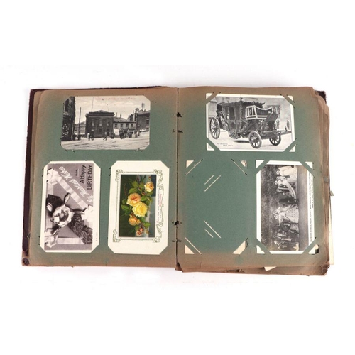 21 - An early 20th century postcard album; together with a quantity of photographs and ephemera.