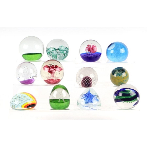 253 - A collection of glass paperweights to include Caithness, Murano and Selkirk.