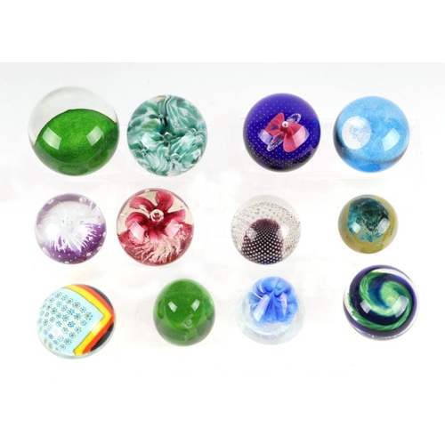 253 - A collection of glass paperweights to include Caithness, Murano and Selkirk.