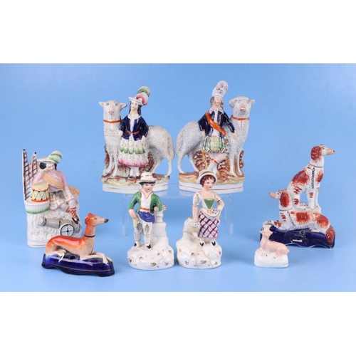 313 - A group of 19th century Staffordshire pottery figures to include a greyhound pen stand, the largest ... 