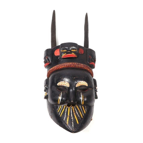 337 - A large South American painted wooden  mask with horned headdress and articulated jaw, 99cms high.