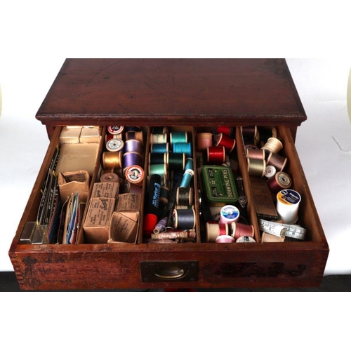 360 - A haberdasher's stained wooden two-drawer chest  containing a large amount of sewing related items, ... 