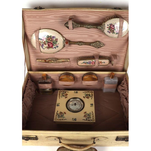 362 - A pigskin suitcase with fitted interior containing a petit point dressing table set.