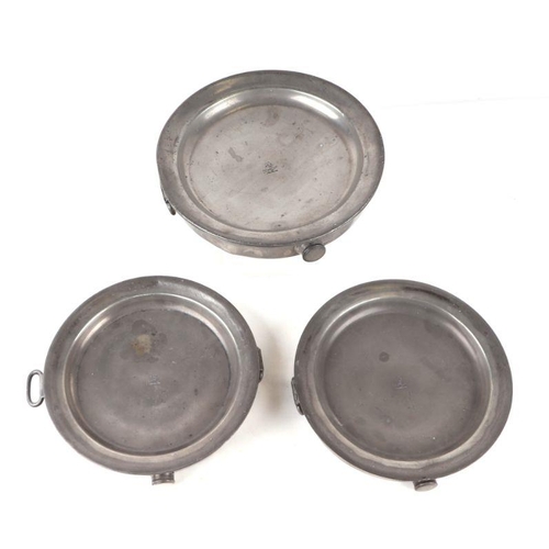 396 - Three early 19th century pewter hot plates, each engraved with an armorial, 26cms diameter (3).