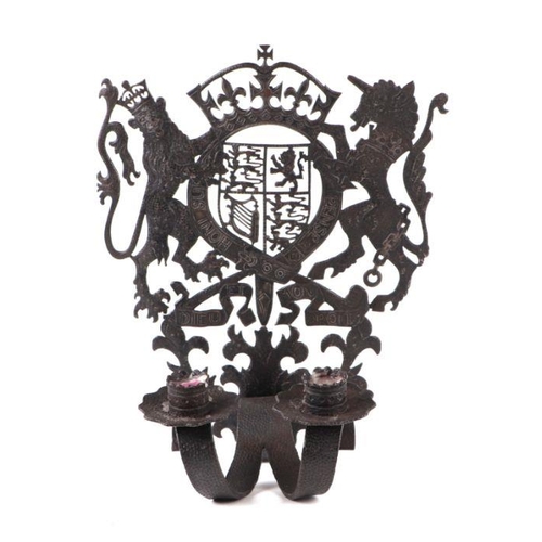 398 - A pierced wrought iron twin-arm candle sconce with Royal Coat of Arms, 30cms high.